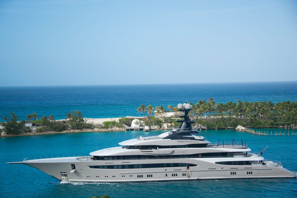 Aerial view of a boat over turquoise water and coral reefs in the Bahamas